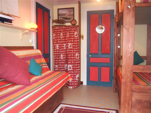 A room with stowaway beds and 1 single bed, television, modern furniture.
